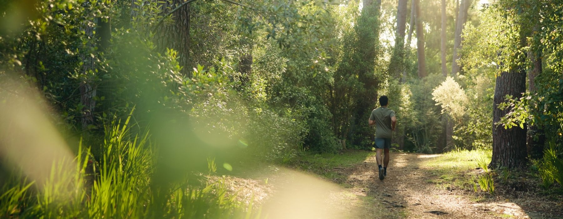 a man running on a trail in the woods